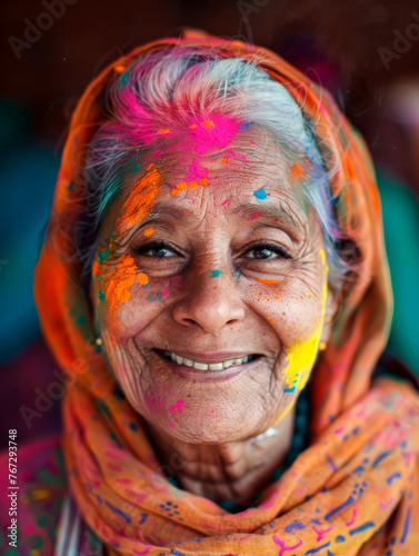 Aging gracefully: moman's smiling portrait with Holi paint