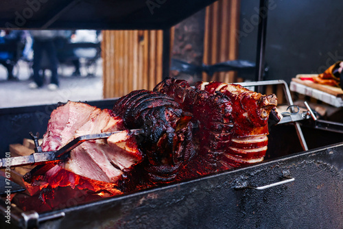 Street food, Czech republic Traditional cuisine Smoke Ham. Close up Slow cook Roasted pork ham over open firewood.