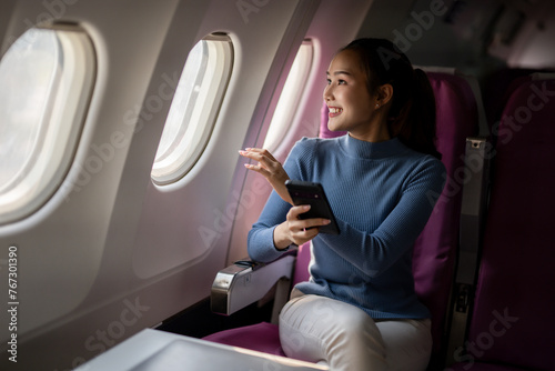 Woman with Smartphone Enjoying Airplane Window View