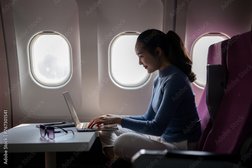 Woman Working on Laptop During Flight Woman Working on Laptop During Flight