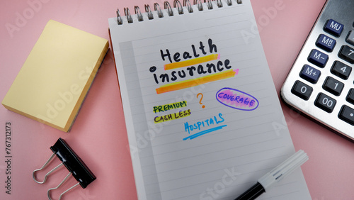 Concept of health insurance written on note pad while doing plan for insurance.