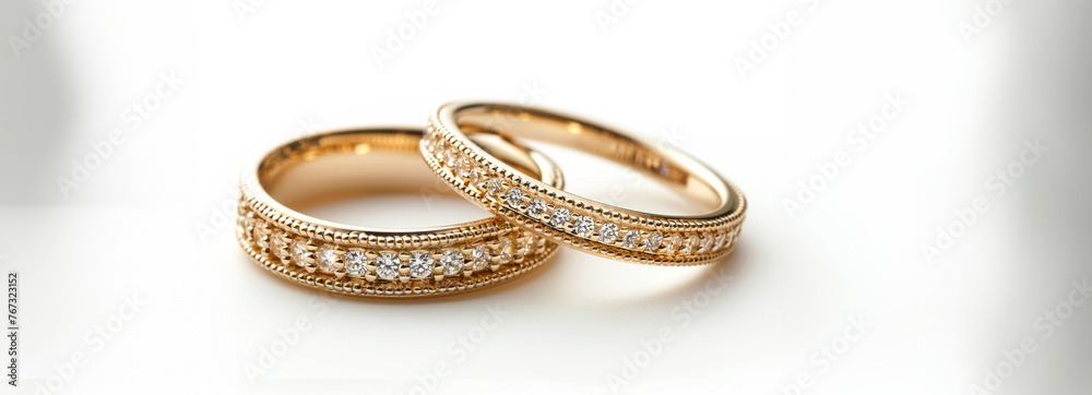 Exquisite Gold Wedding Bands Adorned with Precious Stones on a White Background, Radiating Elegance