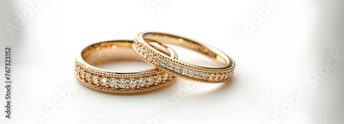 Exquisite Gold Wedding Bands Adorned with Precious Stones on a White Background, Radiating Elegance