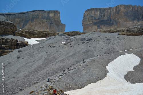 Brèche de Roland, a group of people hiking in the French Pyrenees mountains, snow sund and rocks with the blue sky