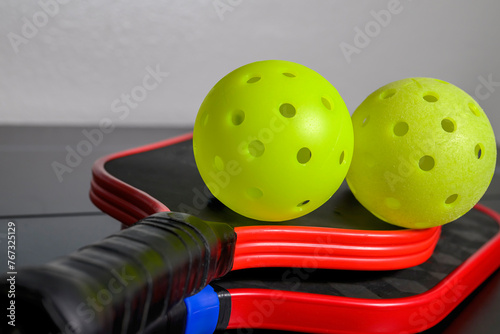 Pickleballs and paddle. The sport of pickleball has become very popular in the last several years.  © justasc