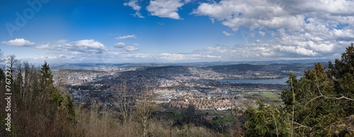 Large panorama of the city of Zurich from the Uetliberg under a blue sky with white clouds
