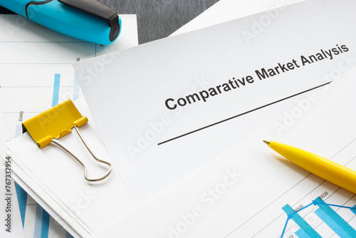 A comparative market analysis report from a stack of papers with graphs.