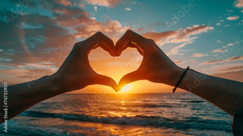 hands shaping a heart around a soft, warm sunset on the horizon, photo stock photo