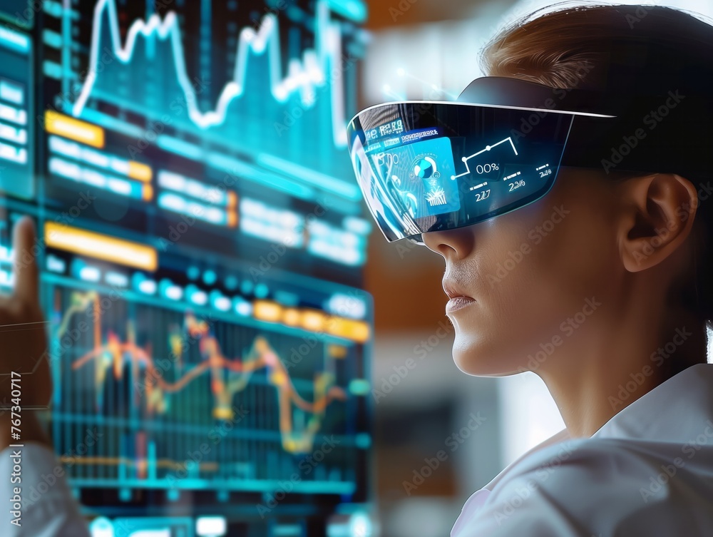 A woman wearing a virtual reality headset is looking at a computer screen with graphs and numbers. Concept of technology and innovation, as well as the idea of being immersed in a digital world - obrazy, fototapety, plakaty 