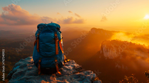 Backpack on rocky peak at golden hour