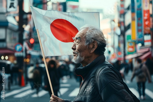 old man hold national flag of Japan on city street