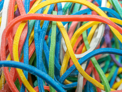 Chaos of many rubber bands of different colors, close up. Abstract background. 