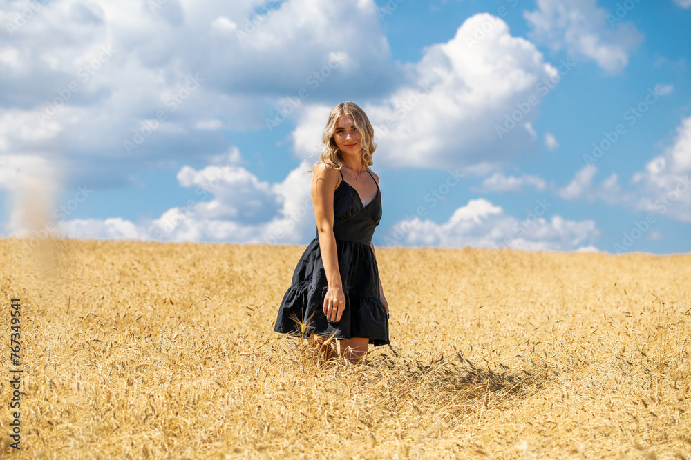 Portrait of a young beautiful blonde woman in black summer dress Portrait of a young beautiful blonde woman in black summer dress