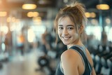 happy attractive sporty fit young woman on blurry gym background, fitness and health concept, sport banner with copy space