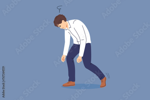 Tired man bends over and closes eyes due to exhaustion caused by overwork and overload. Business guy feels drowsy and exhaustion after completing difficult job on behalf of manager.
