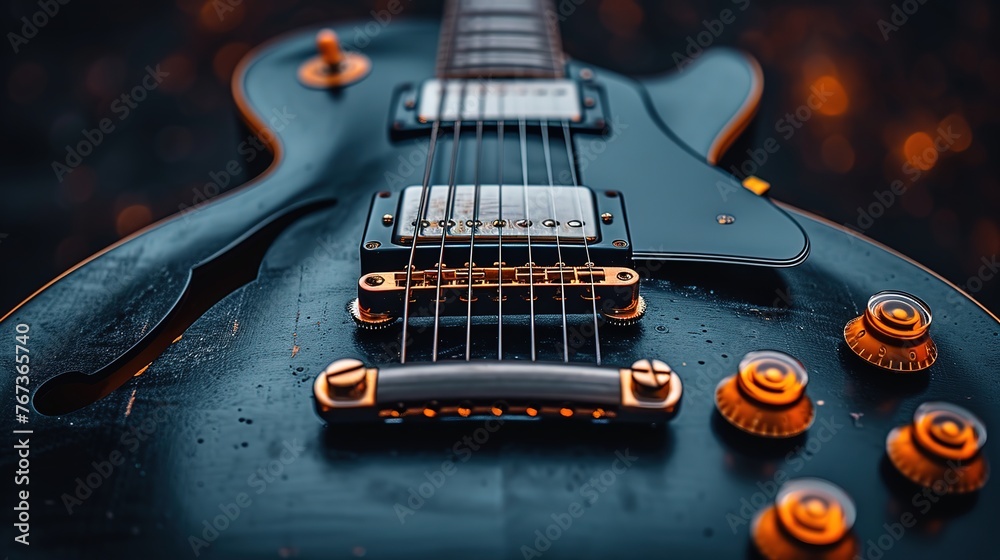 Black electric guitar on a dark background. Close-up view