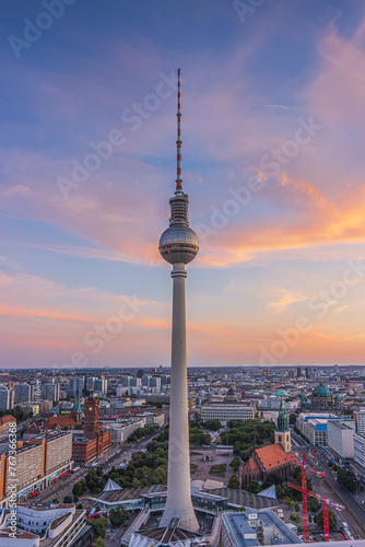 Television tower in the center of Berlin. Tallest building in Germany at Alexanderplatz at sunset. Skyline of the capital with Red Town Hall in the evening. Top view of city buildings and roofs