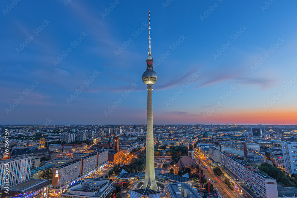 Berlin skyline in the evening at blue hour. Television tower at Alexanderplatz in the center of the capital of Germany. Illuminated buildings and streets with the Red Town Hall