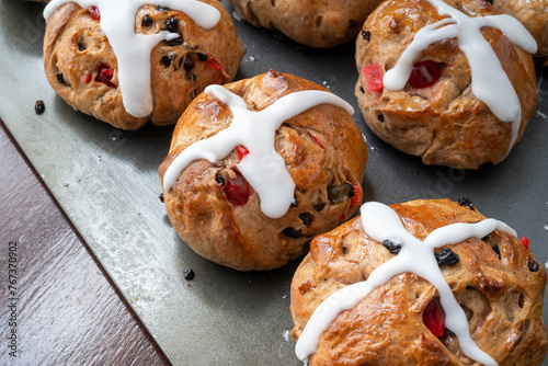 Homemade traditional hot cross buns with fruit and raisins.