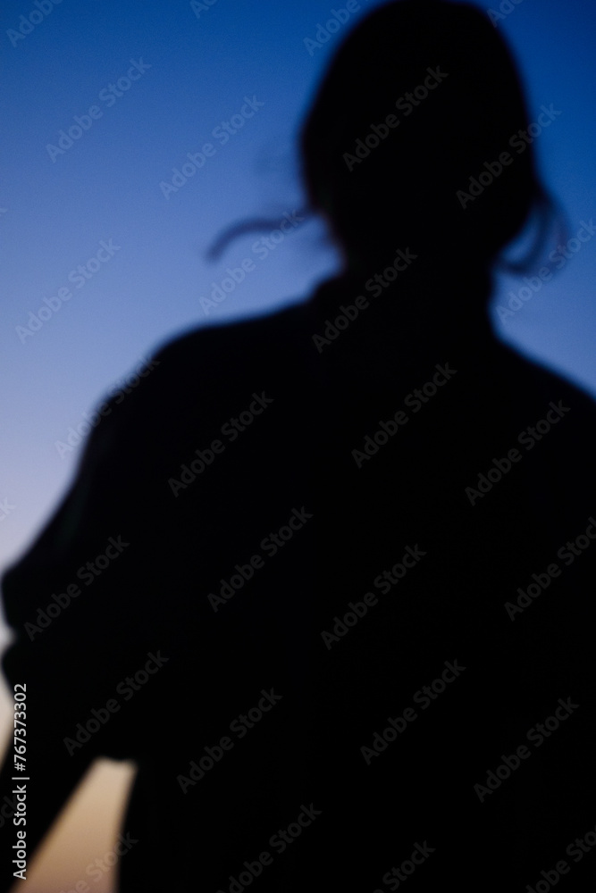 silhouette of a woman with a blue hour sunset background