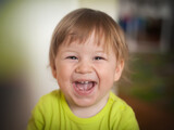 Beaming smile of happy cute toddler in a cozy home setting at playtime exuding pure happiness. Love and family concept