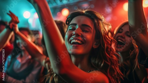 A group of happy friends are dancing at a concert in a club, celebrating and enjoying the nightlife