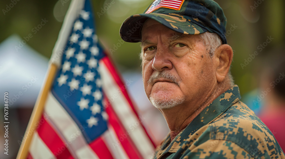 A veteran holding an American flag at a 4th of July remembrance ceremony.