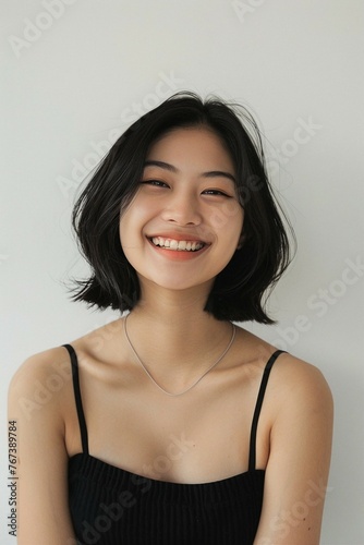 Smiling Young Woman in White Top with Short Hair
