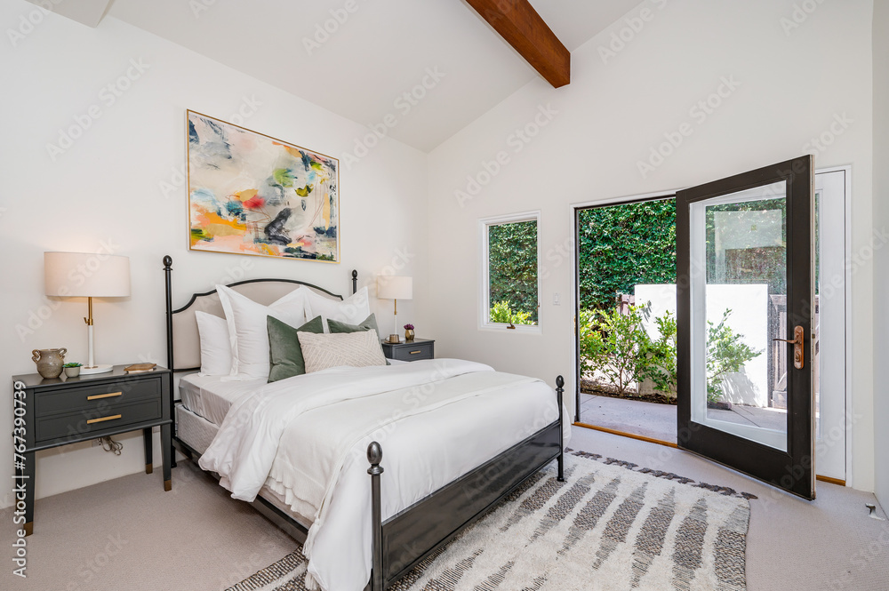 Fototapeta premium a bedroom with a bed in the middle of it and glass doors
