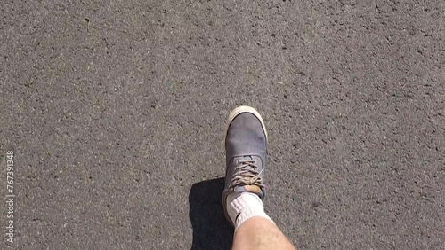 Close-up of a persons foot taking a step on a cracked asphalt road