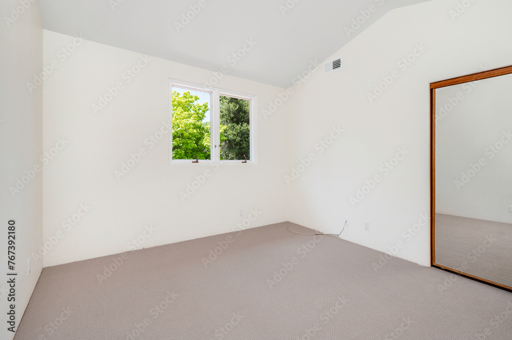 Obraz premium a small empty bedroom with the window open and the floor