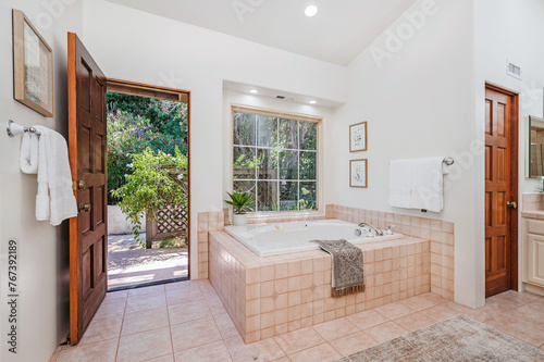 a clean bathroom with tiled floor and white walls  large windows  two sinks and