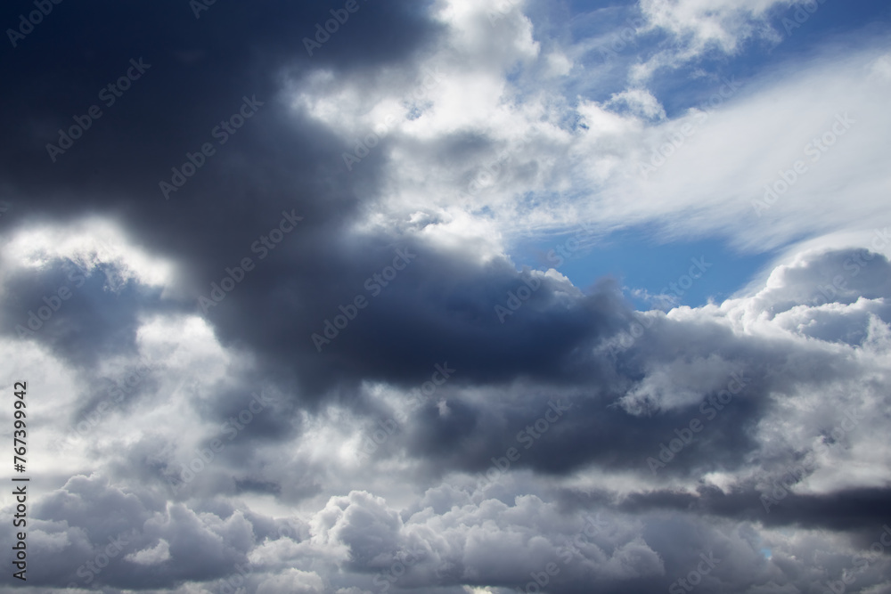 Storm clouds on the sky, torn textured clouds on a blue sky Storm clouds on the sky, torn textured clouds on a blue sky