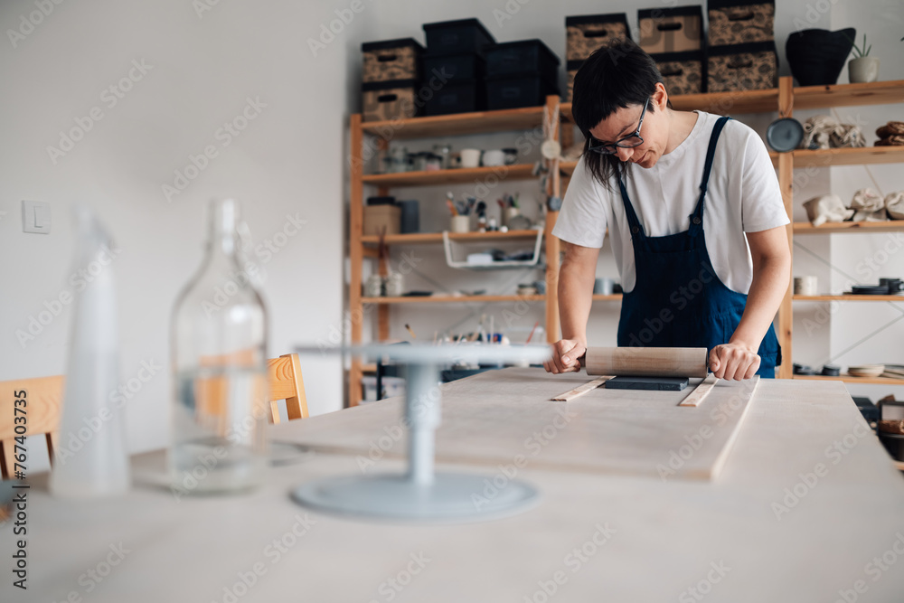 A creative craftswoman molding clay at her ceramics workshop. A creative craftswoman molding clay at her ceramics workshop.