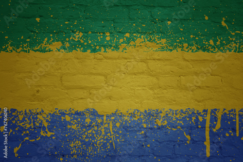 colorful painted big national flag of gabon on a massive brick wall