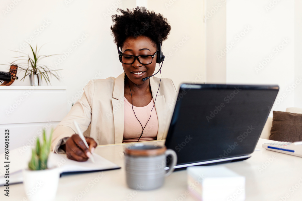 Woman on video call with work from home laptop, headphones and virtual international online meeting. Hello, wave and African person in webinar for remote working or global update in computer. Woman on video call with work from home laptop, headphones and virtual international online meeting. Hello, wave and African person in webinar for remote working or global update in computer.