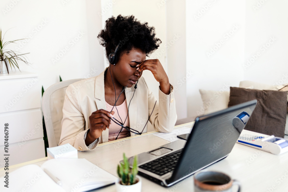 Cropped shot of an attractive young woman sitting in her home and suffering from a headache while using her laptop. - obrazy, fototapety, plakaty 