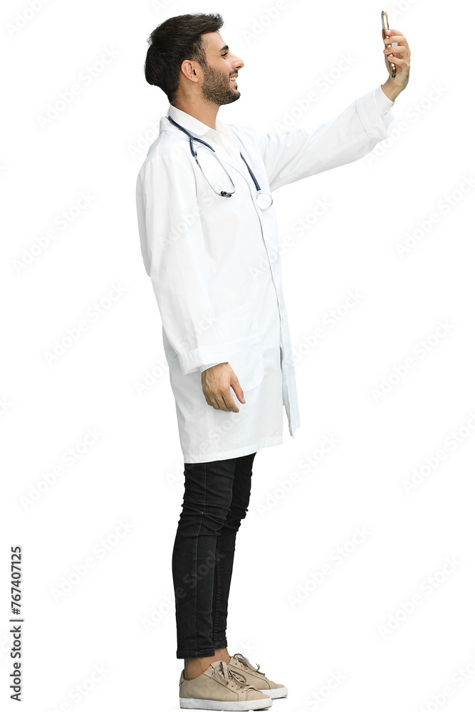 A man doctor conversate with phone on a green background, in profile A man doctor conversate with phone on a green background, in profile