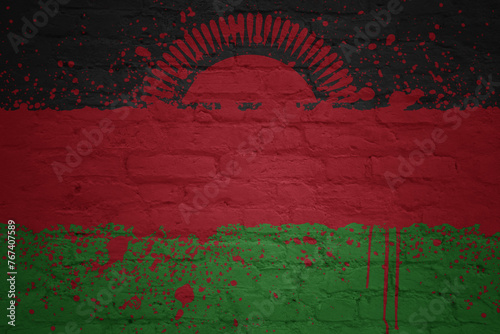 colorful painted big national flag of malawi on a massive brick wall