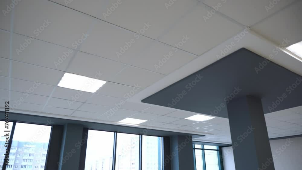 Square lamps on a white office ceiling. Interior design in the office. A fluorescent lamp on a modern suspended ceiling.