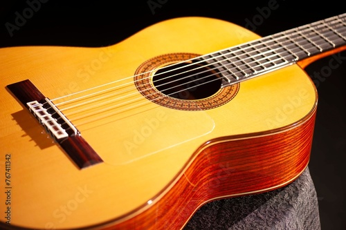 Classical Spanish flamenco guitar close up, dramatically lit isolated on black background with copy space.