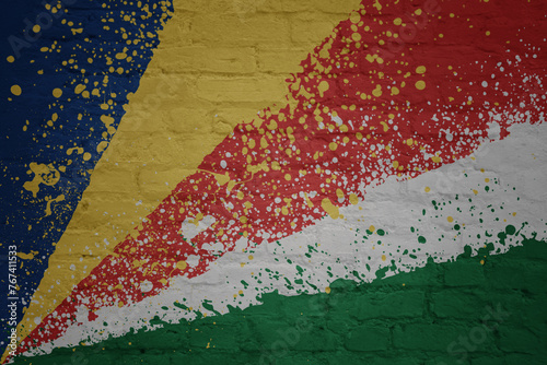 colorful painted big national flag of seychelles on a massive brick wall