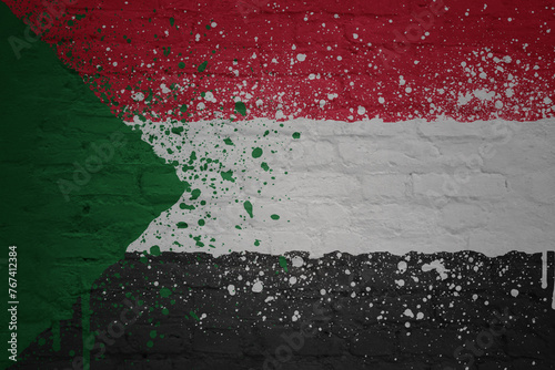 colorful painted big national flag of sudan on a massive brick wall