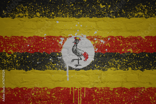 colorful painted big national flag of uganda on a massive brick wall