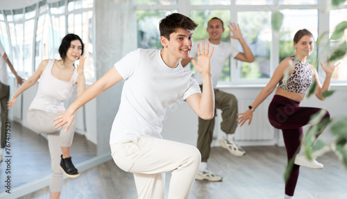 Smiling people practicing vigorous lindy hop movements in dance class