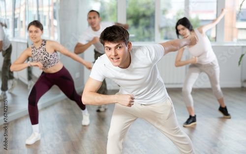 Smiling people practicing vigorous lindy hop movements in dance class