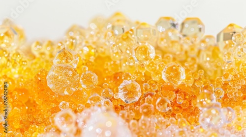  a close up of a bunch of bubbles in a yellow and yellow liquid filled with yellow and white bubbles on a white surface.