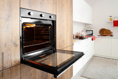 Fotografie Wooden furniture with built-in oven in modern kitchen