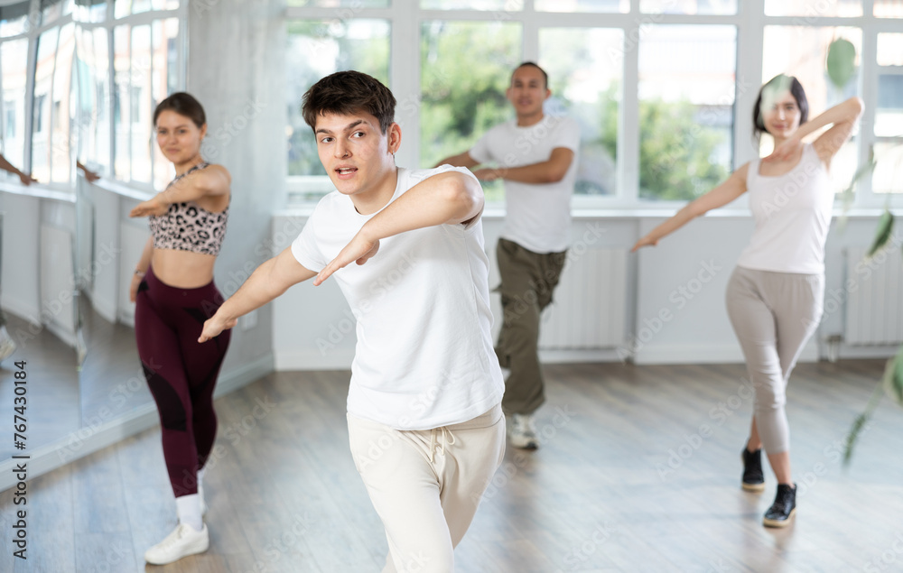 Fototapeta premium Group of young guys and girls dancing jazz funk in the studio
