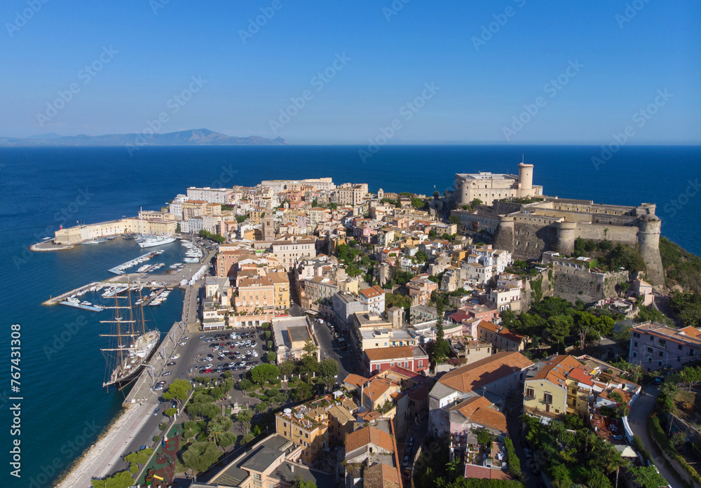 Panorama of Gaeta city, port and sea from drone. sunny day, blue sky and blue water in the sea. the ship is docked in the port of the old city. the Apennine Mountains are far in the background
